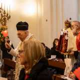 ...che avanza in chiesa seguito da una fila di preti e canonici